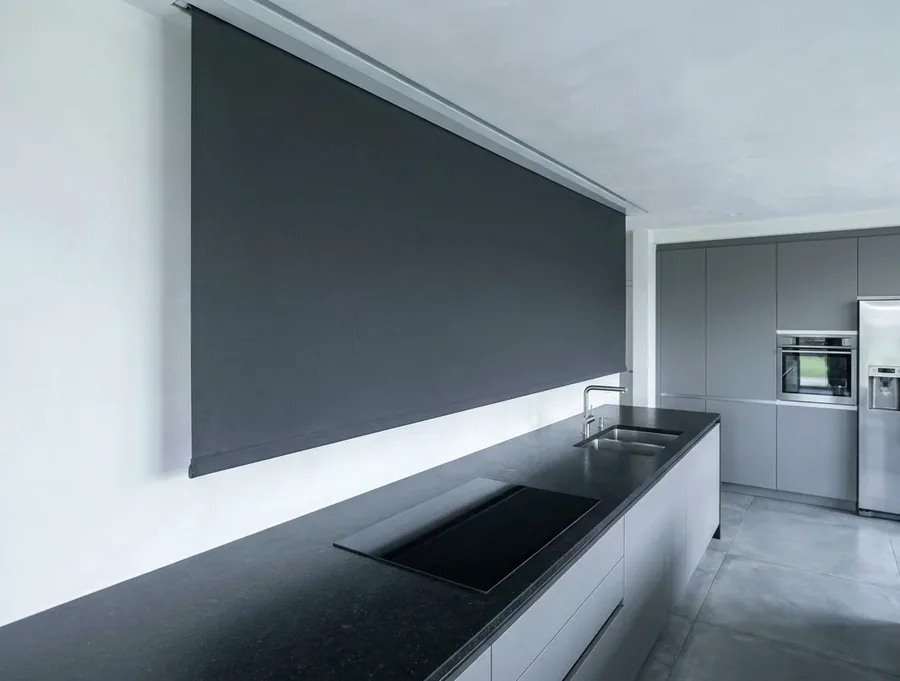 A roller blind dropping from a concealed ceiling recess in a kitchen, with no visible headbox
